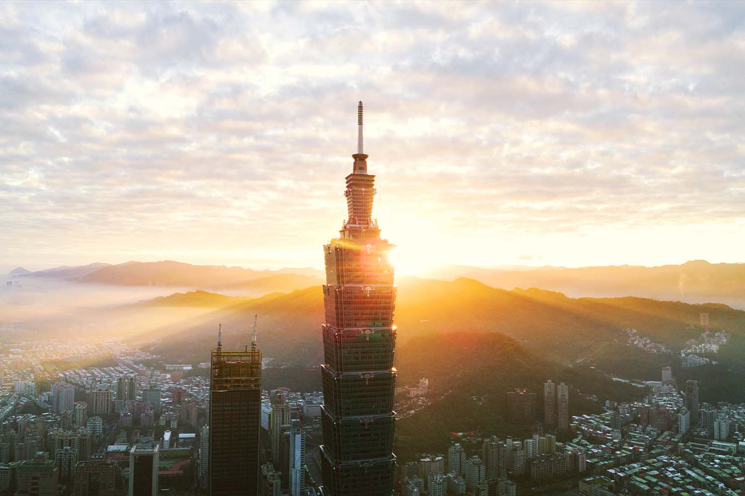 Taipei 101 Tower in Taiwan with the sun shining in the background