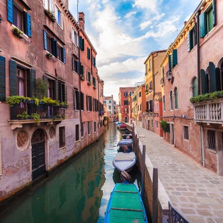 small venice canal with pink buildings on either side