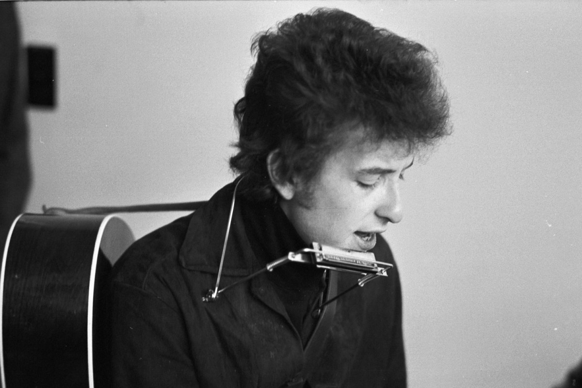 black and white photo of Bob Dylan with a harmonica