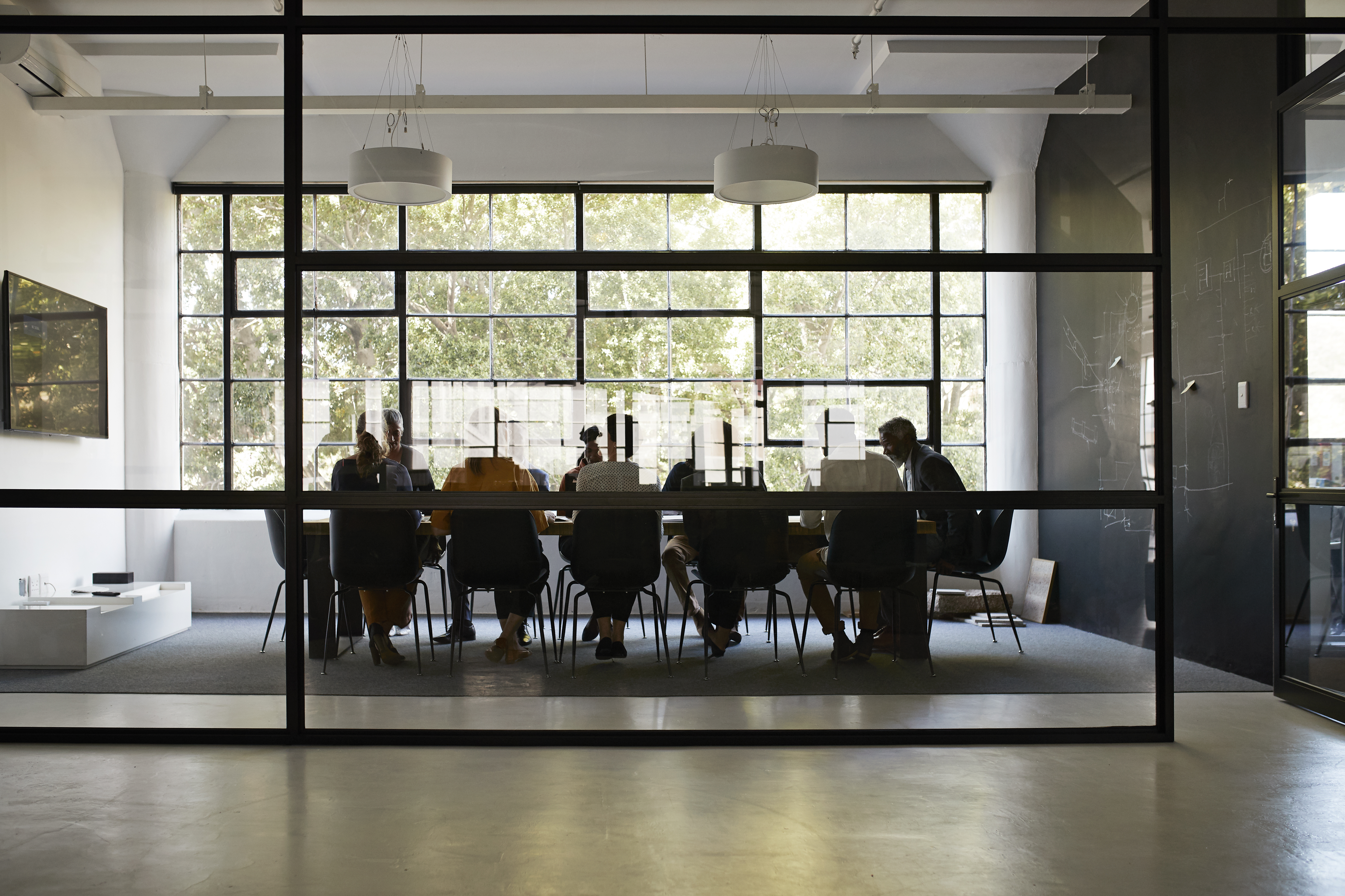 A shot of a board room through a glass window.
