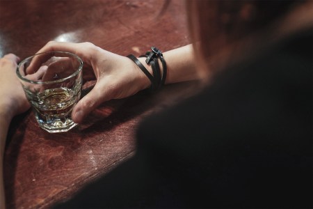 Woman drinking a shot of whisky in a bar