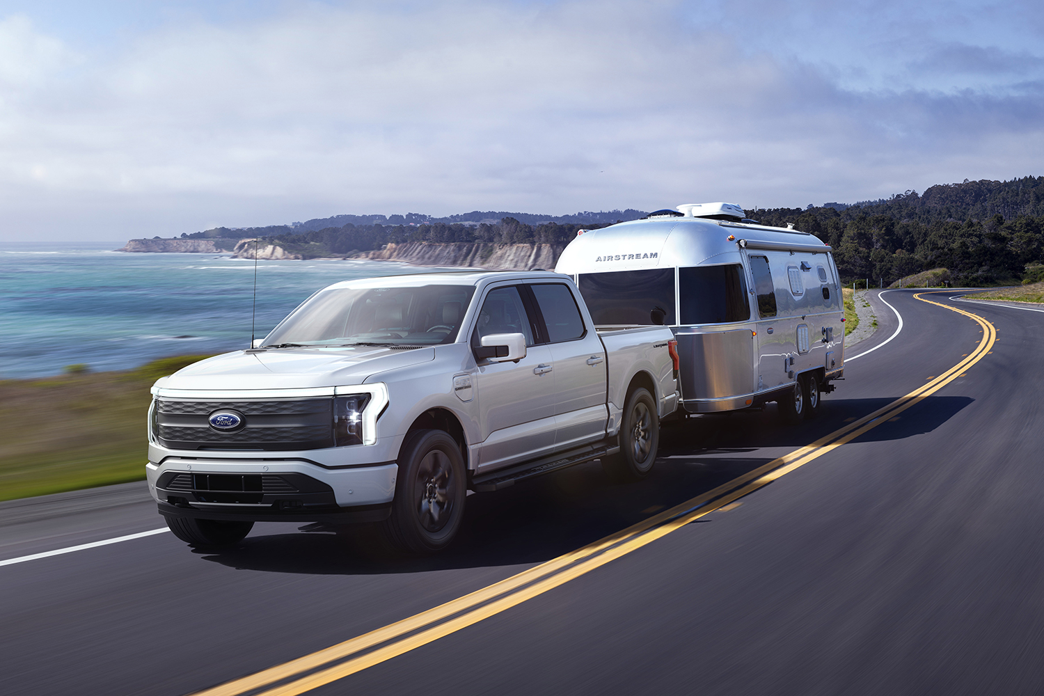 A Ford F-150 Lightning Lariat, a mid-tier trim of the electric pickup truck, towing an Airstream travel trailer