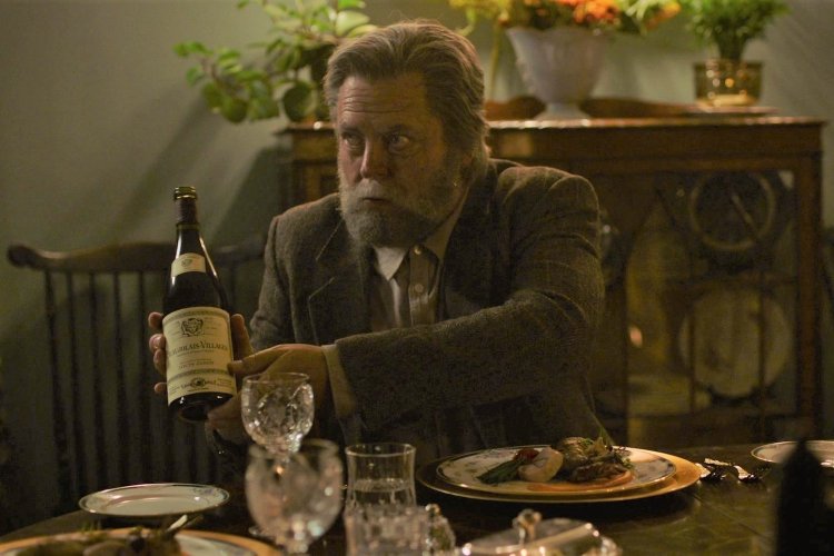 dinner scene from the last of us with nick offerman holding a bottle of wine