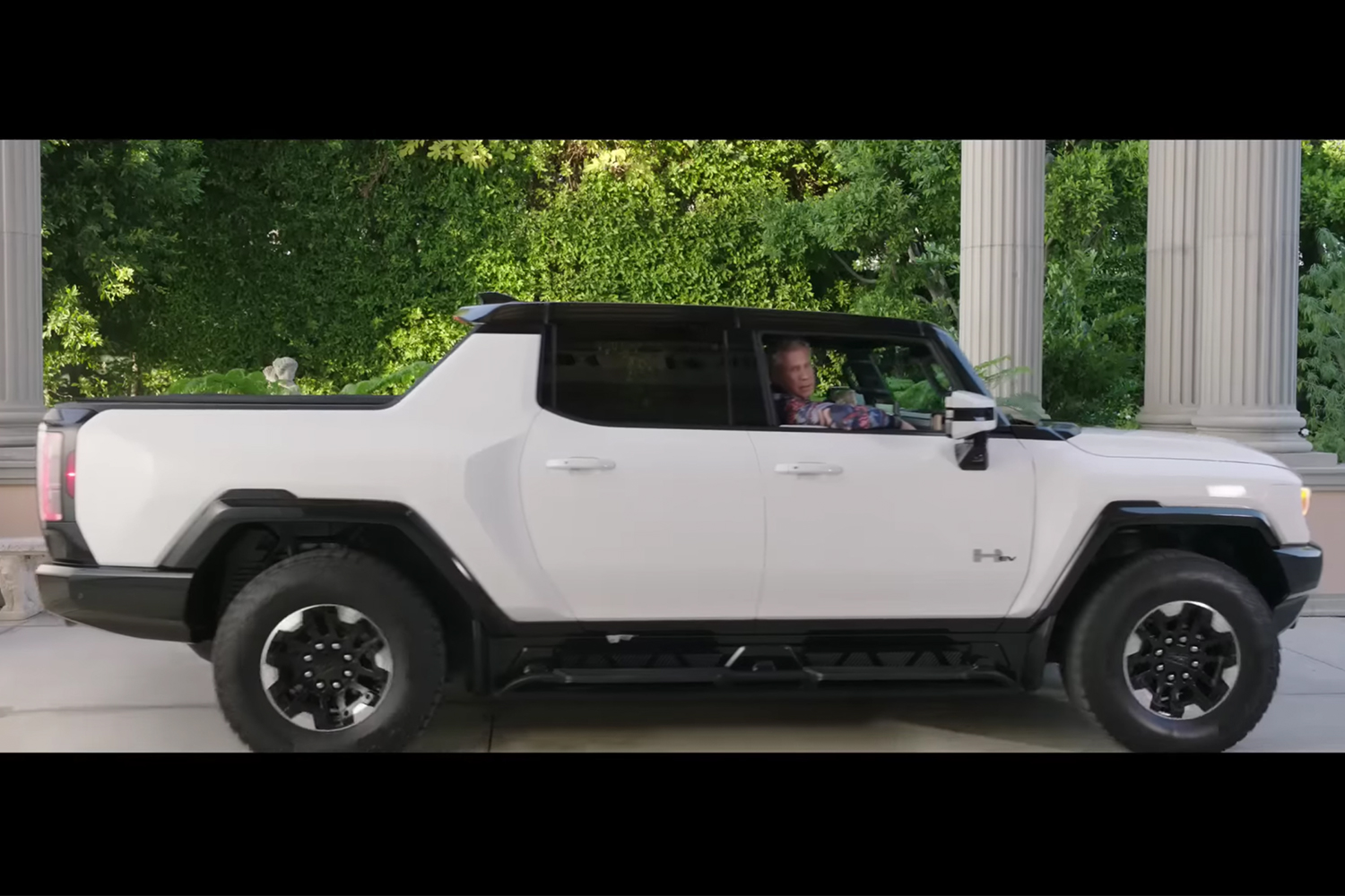 Will Ferrell sits in the passenger seat of a GMC Hummer EV Pickup in the Netflix and GM Super Bowl ad for 2023