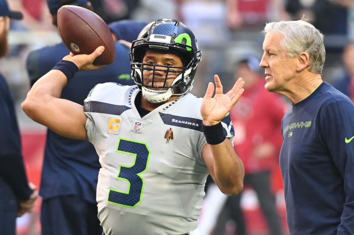 Russell Wilson throws the ball as Pete Carroll looks on in 2022.