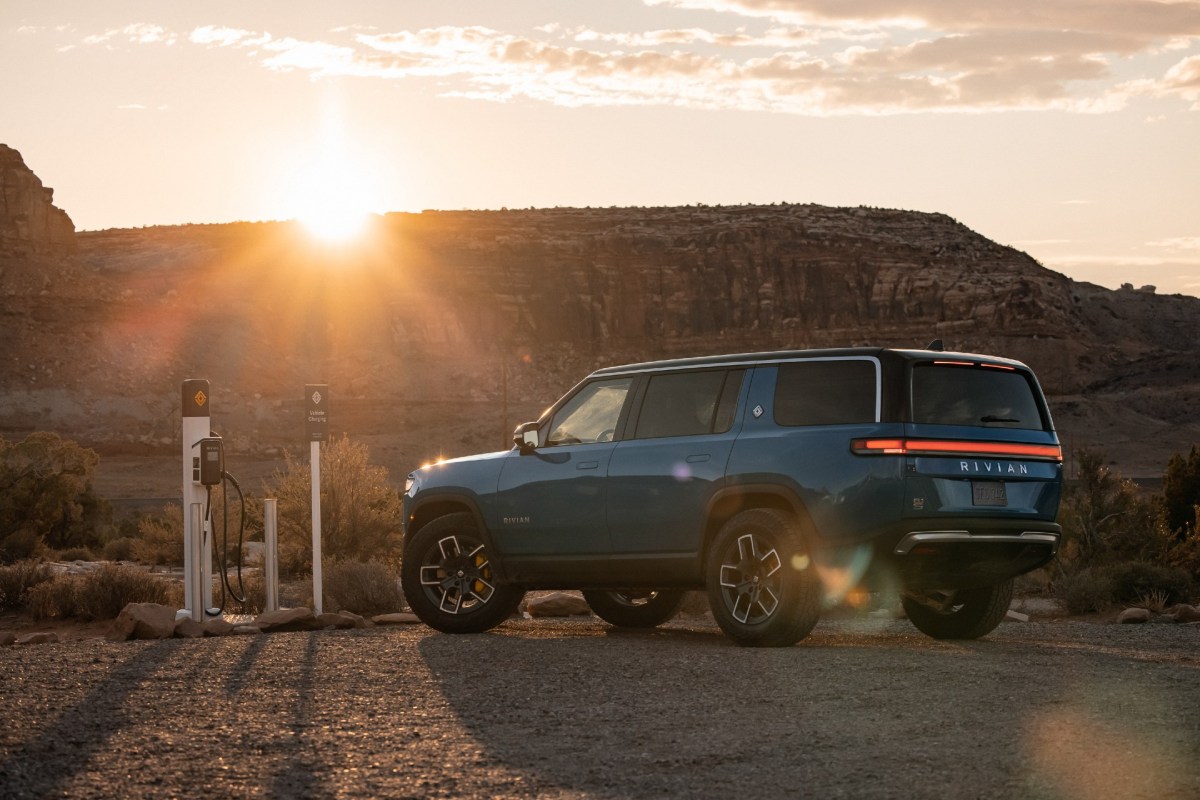 A Rivian R1S SUV charging as the sun sets. The EV startup wants to add an e-bike to its lineup.