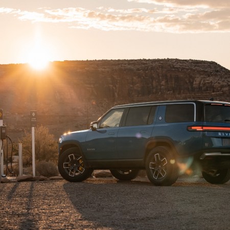 A Rivian R1S SUV charging as the sun sets. The EV startup wants to add an e-bike to its lineup.