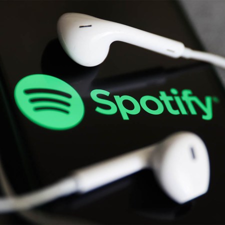 Spotify logo displayed on a phone screen and headphones are seen in this illustration photo taken in Krakow, Poland on July 12, 2022. Spotify is testing out a new AI DJ feature.