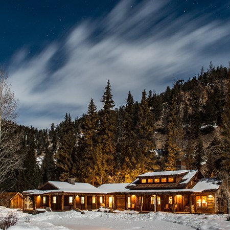 Taylor River Lodge, located in Colorado, pictured here at night covered in snow during the winter