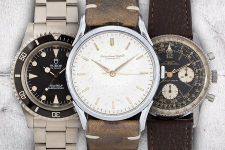 three vintage watches under $10,000 on a gray background