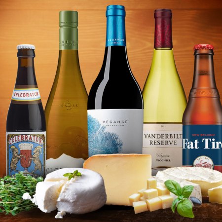 a bunch of wines, beers and cheese on a wooden background