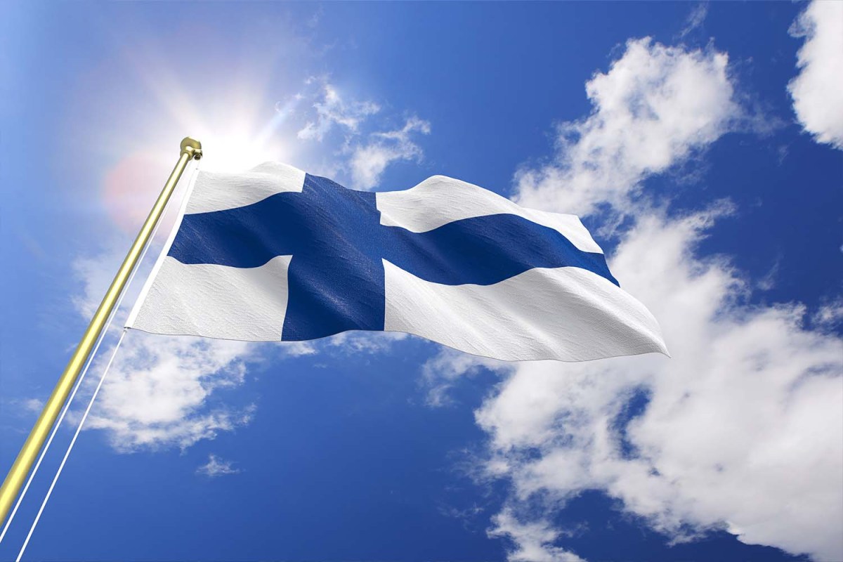 finland flag against a blue sky with white clouds