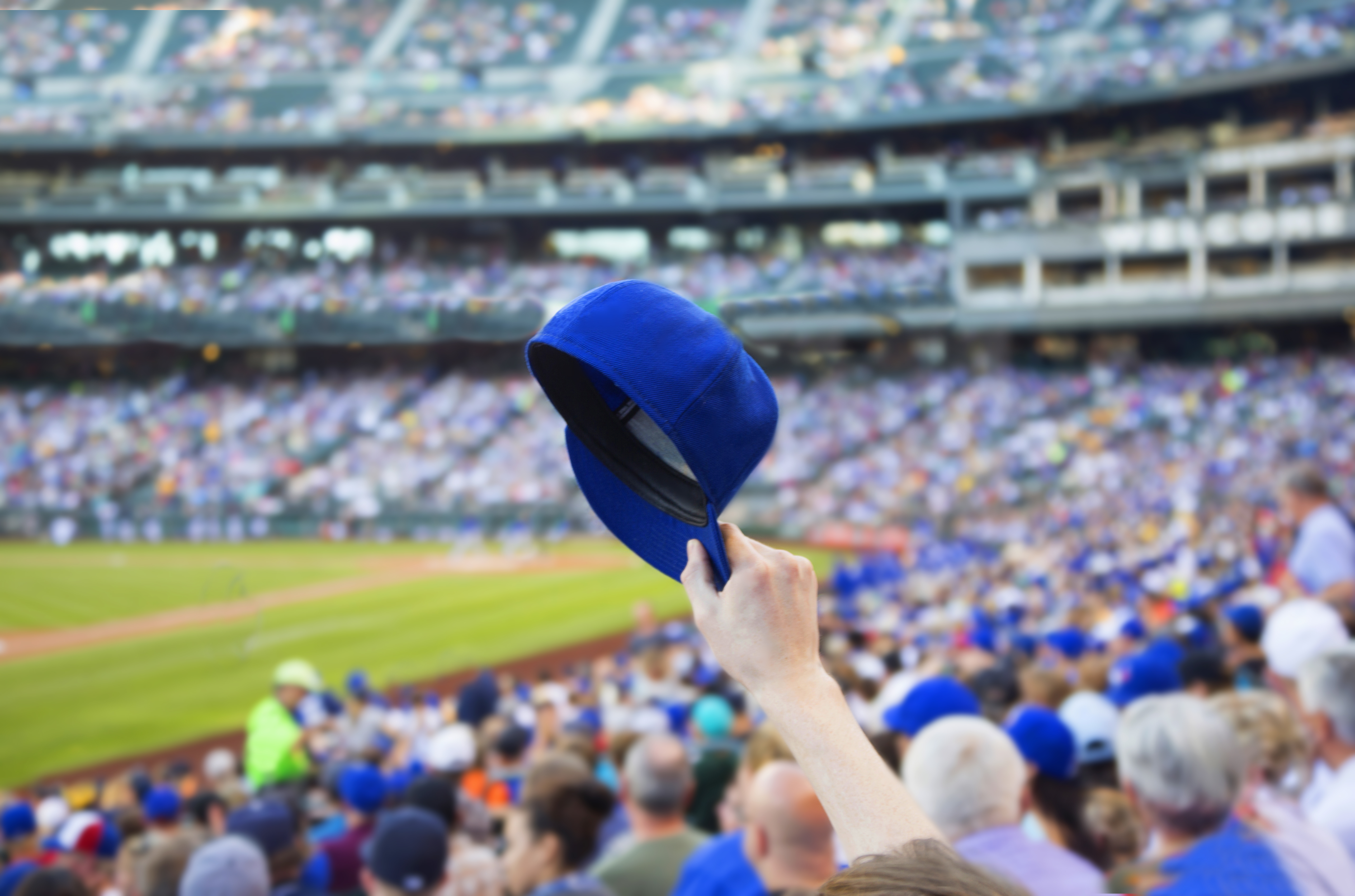 Man holding up baseball cap.