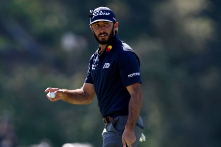 Max Homa walks a course holding his golf ball
