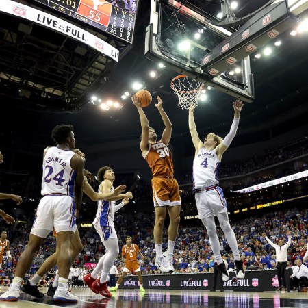 Brock Cunningham #30 of the Texas Longhorns shoots the ball against Gradey Dick #4 of the Kansas Jayhawks during second half of the Big 12 Tournament Championship game at T-Mobile Center on March 11, 2023 in Kansas City, Missouri.