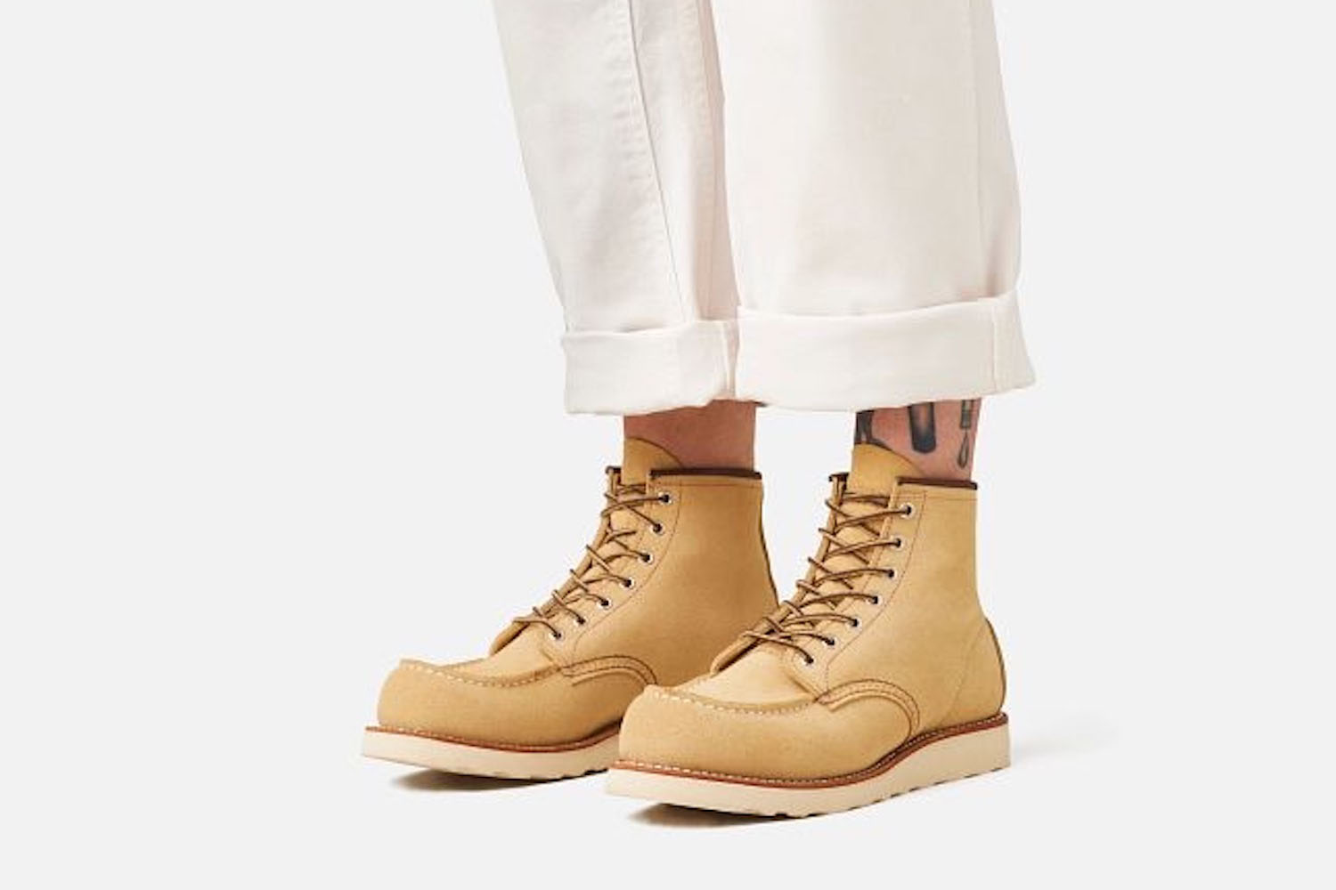 a model in a pair of tan Red Wing boots on a white background