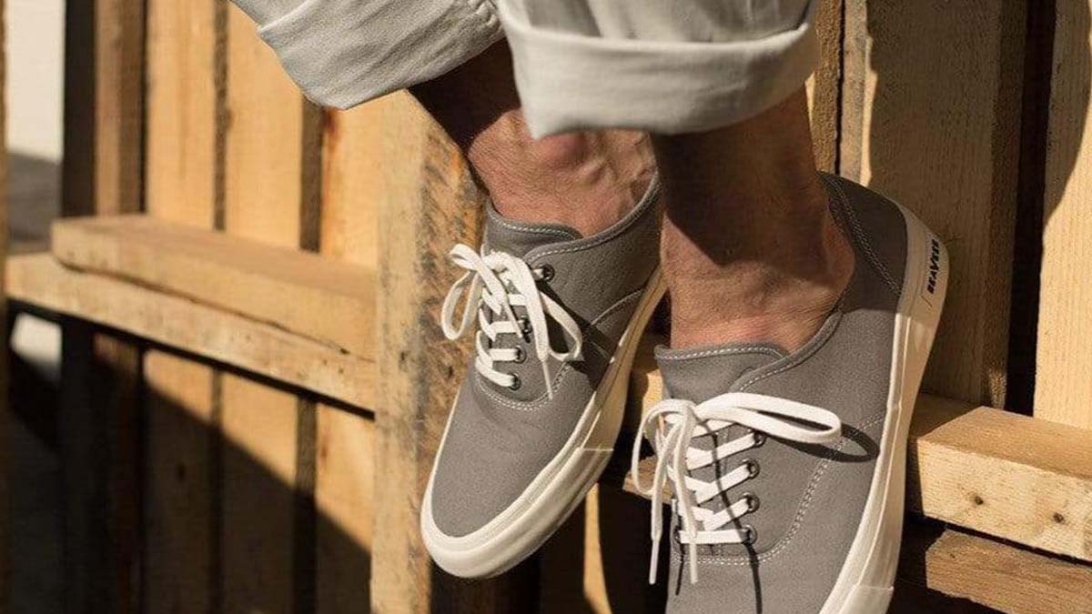 a close-up of a person wearing grey SeaVees Legend sneakers. The sneaker site is hosting a 30% off sale.