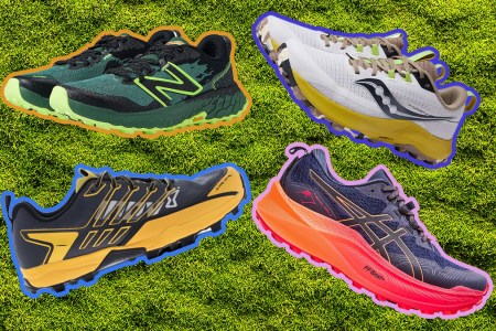 Four trail running shoes on a grass background