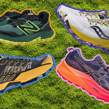 Four trail running shoes on a grass background