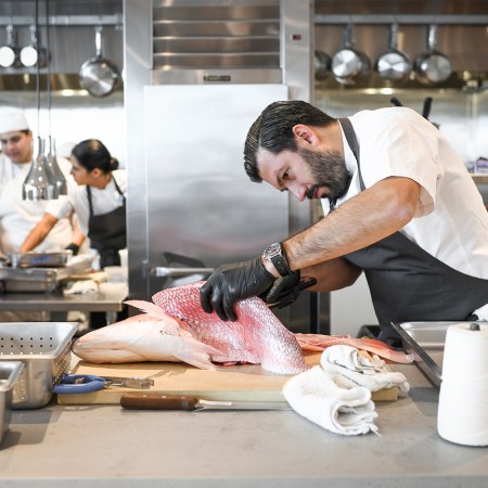 Chef Aaron Bludorn cleaning a fish