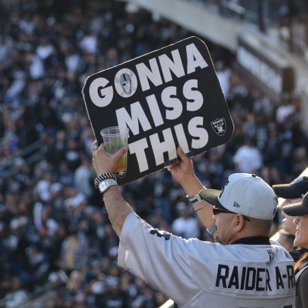 A Raiders football fan holds up a sign reading "Gonna Miss This" during the NFL team's final home game in Oakland, the year 2020.