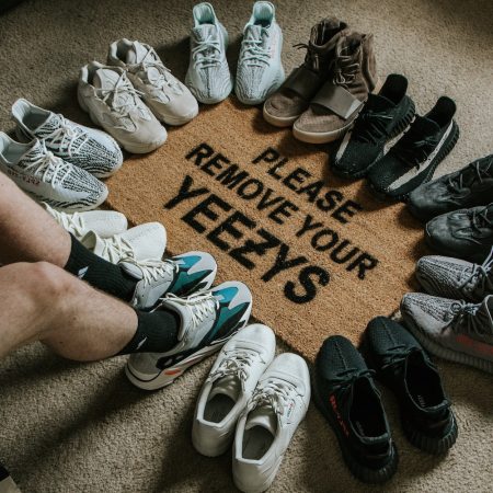 Pairs of Yeezy sneakers circle a welcome mat that says "Please Remove Your Yeezy's" on the floor