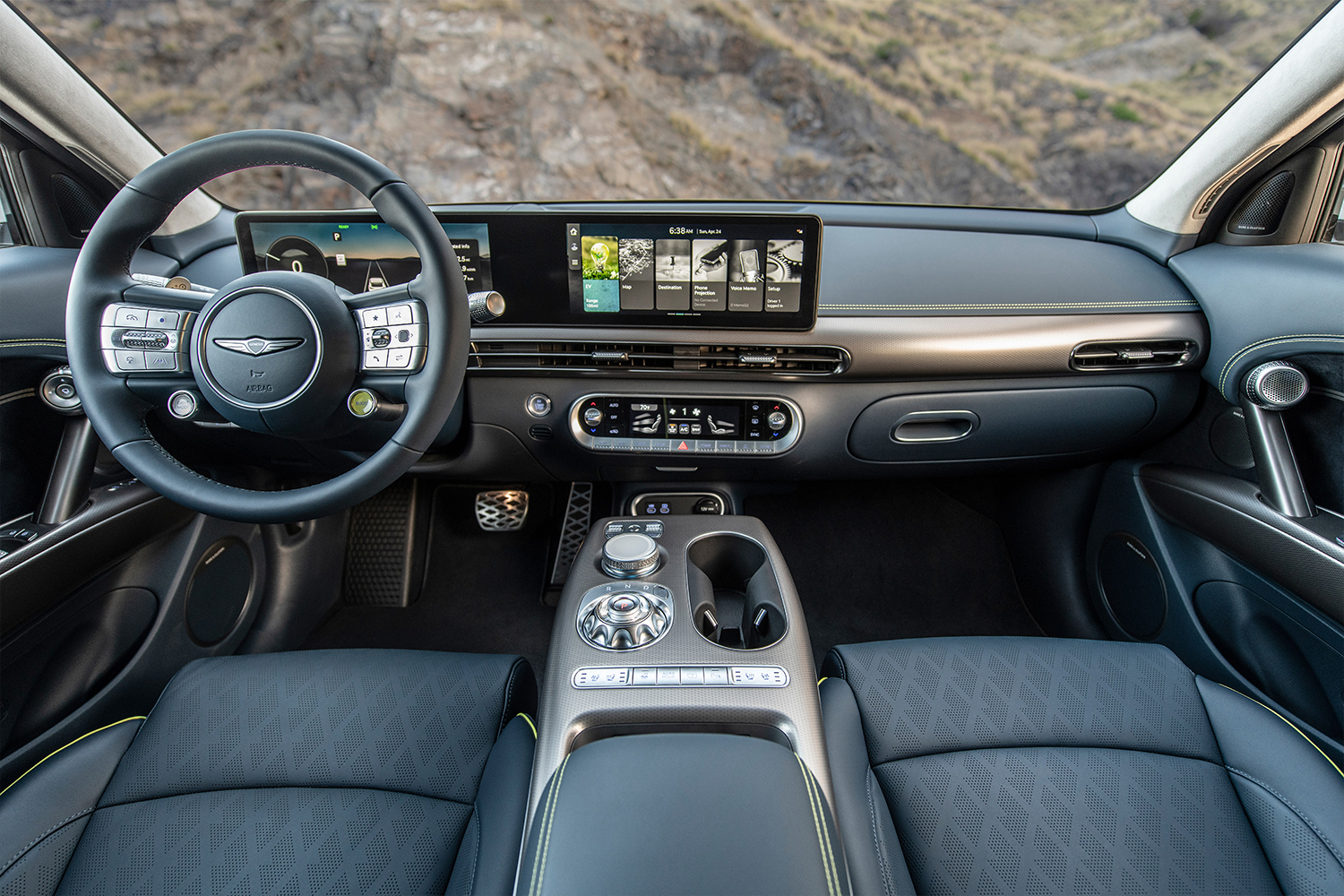 The interior of the Genesis GV60, an electric SUV, featuring a green Boost button on the steering wheel
