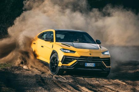 The 2023 Lamborghini Urus Performante SUV in yellow and black driving off-road in the dirt