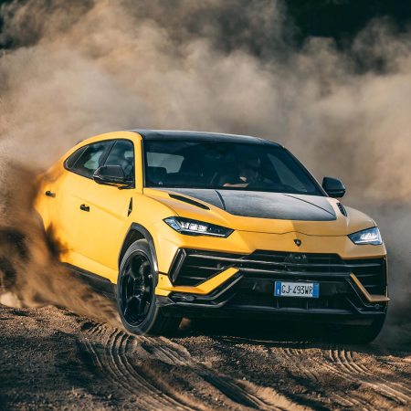 The 2023 Lamborghini Urus Performante SUV in yellow and black driving off-road in the dirt
