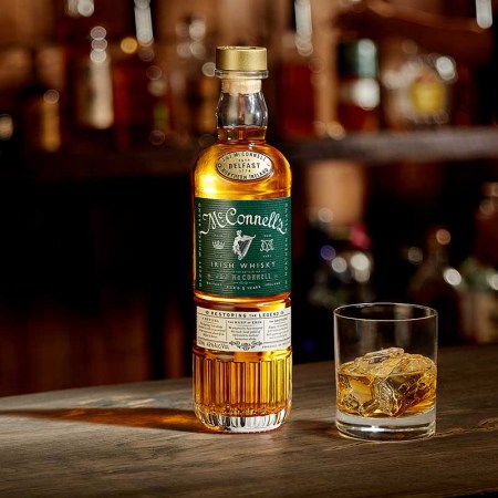 A bottle and a glass of McConnell's Irish Whisky on a bar top