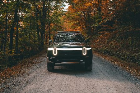 An electric truck from Rivian driving in the forest. Do we have enough raw materials on Earth to build millions of EVs like this?