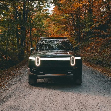 An electric truck from Rivian driving in the forest. Do we have enough raw materials on Earth to build millions of EVs like this?