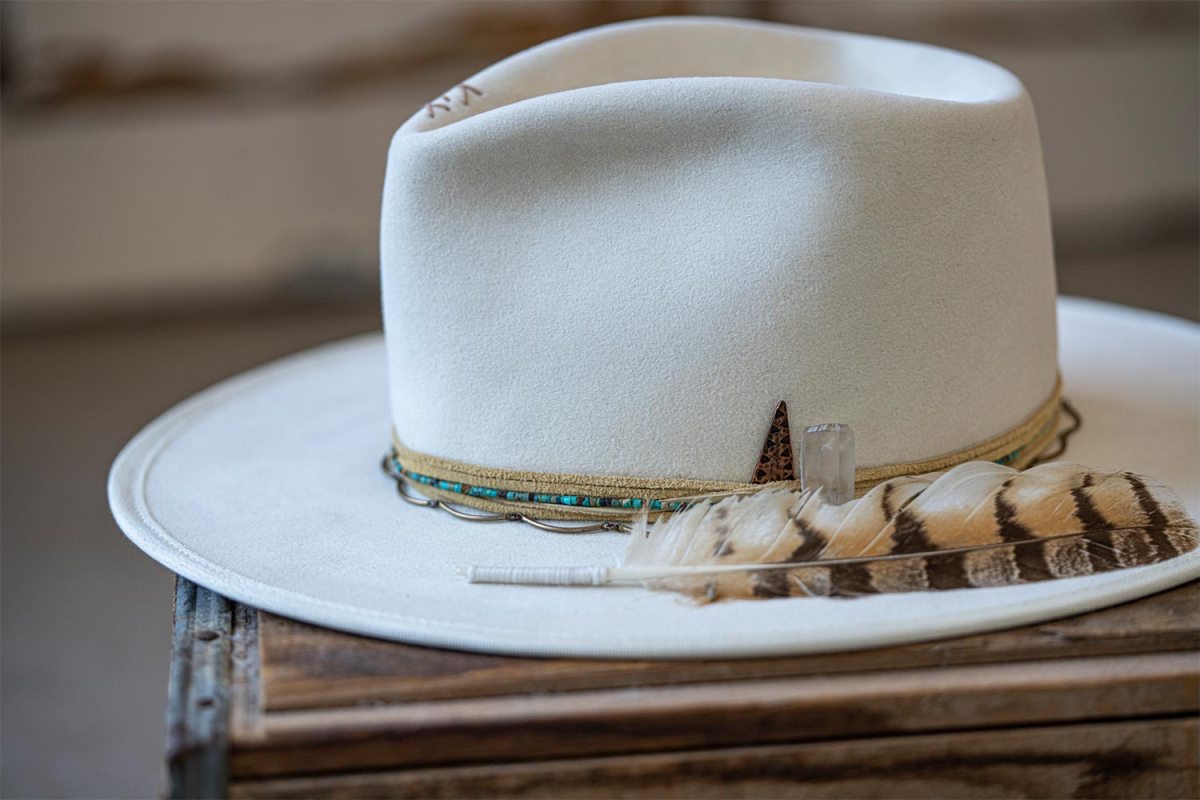 A white hat with a feather from Trovador Customs in Austin, Texas