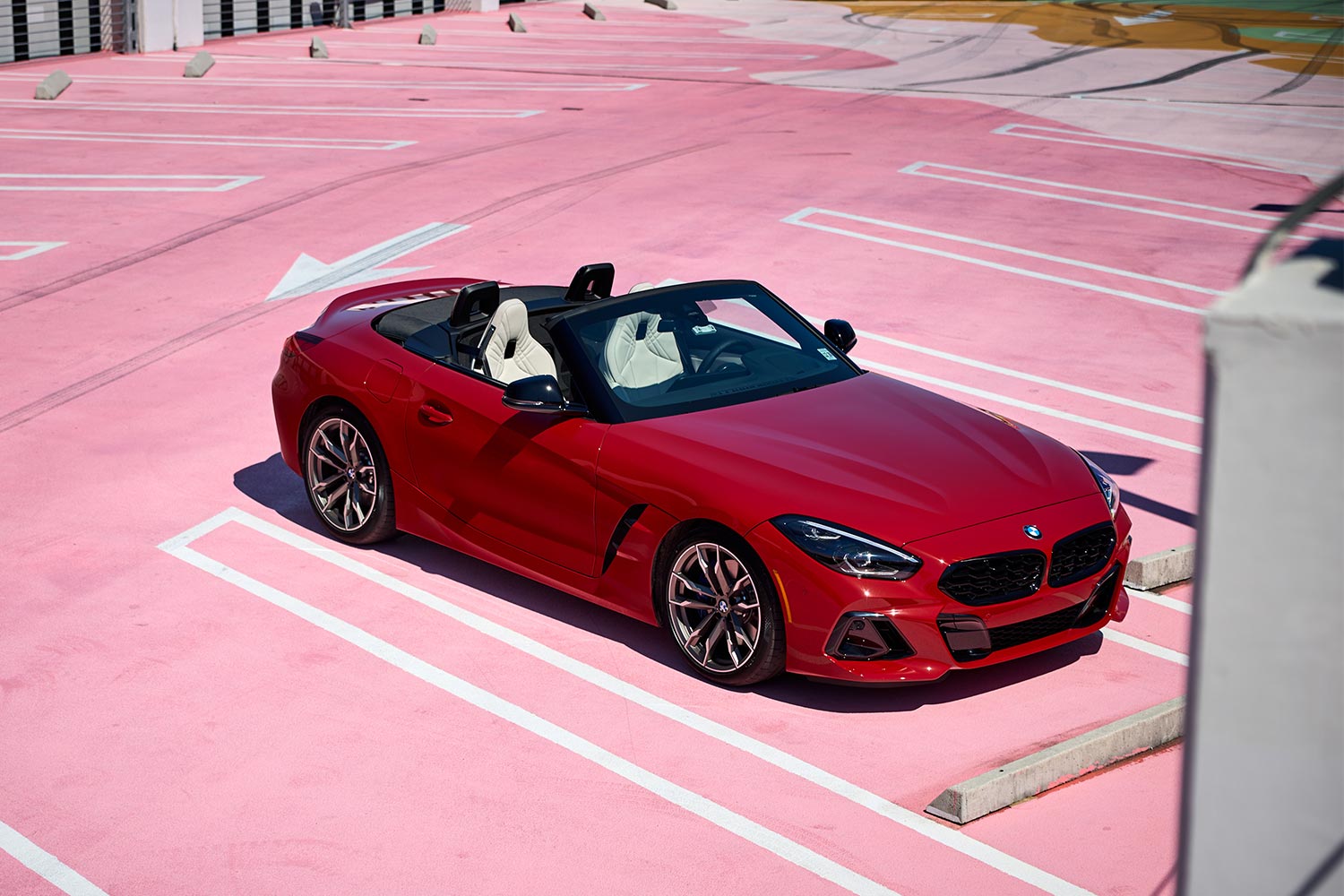 A red 2023 BMW Z4 M40i sitting in a parking lot painted pink
