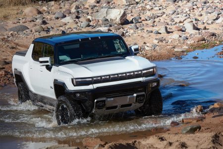 The 2023 GMC Hummer EV, an electric pickup truck, driving through water. Only two of the supertrucks were delivered in Q1 2023.