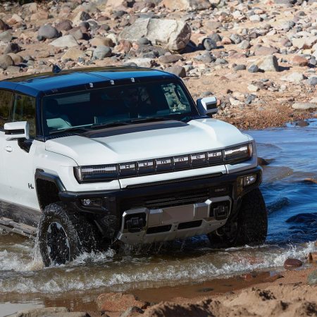 The 2023 GMC Hummer EV, an electric pickup truck, driving through water. Only two of the supertrucks were delivered in Q1 2023.