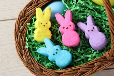 an easter basket willed with green grass and multi-colored bunny marshmallow peeps
