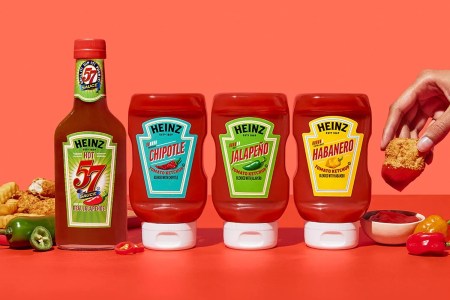 lineup of heinz spicy ketchup and steak sauce with someone dunking a chicken nugget