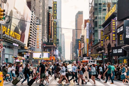 Dozens of people strolling through a crosswalk in New York City
