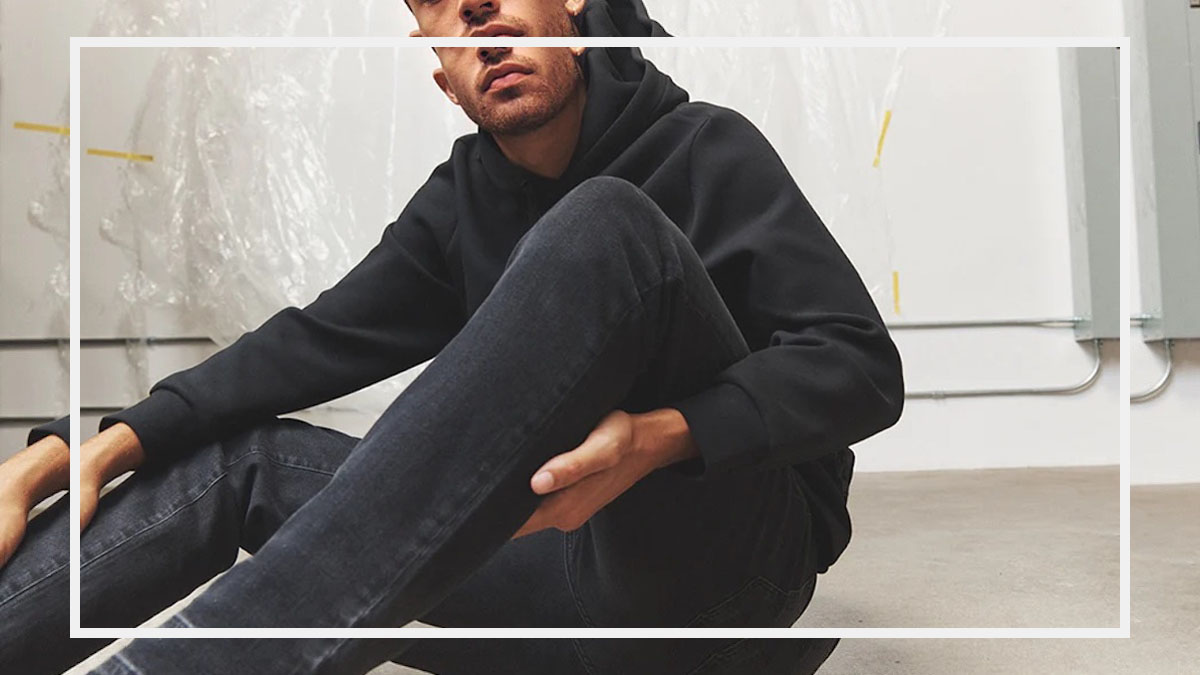 a model wearing DSTLD jeans sitting on a stone floor