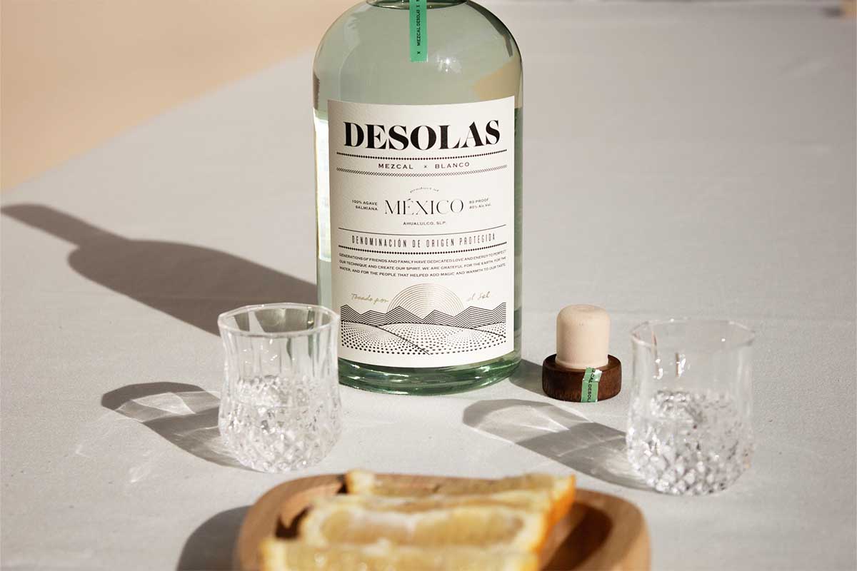 Desolas Mezcal on a table with a glass and orange slices. There's a mezcal for every palate, even if you don't like mezcal.
