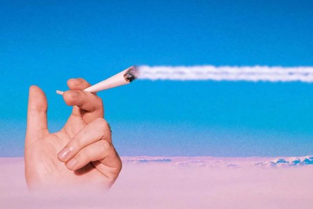 A hand holding a joint above the clouds while the smoke trails across the sky. Here's our guide to getting stoned while flying on a plane.