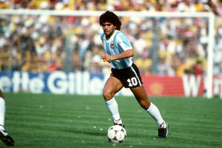 Diego Maradona of Argentina dribbling a soccer ball across the pitch at the 1982 World Cup