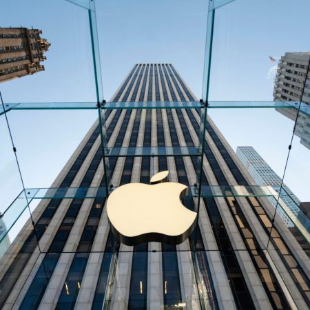 Apple logo on glass city building.