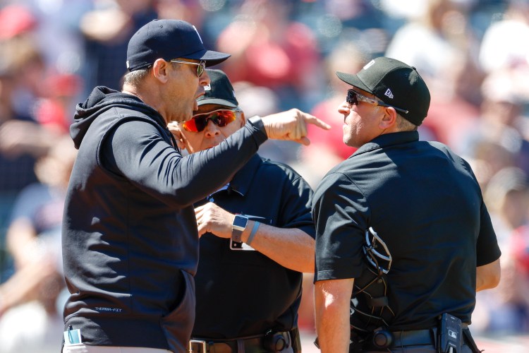 Aaron Boone #17 of the New York Yankees argues a review call with home plate umpires Chris Guccione #68, right, and Larry Vanover #27 after being ejected from the game during the first inning at Progressive Field on April 12, 2023 in Cleveland, Ohio.