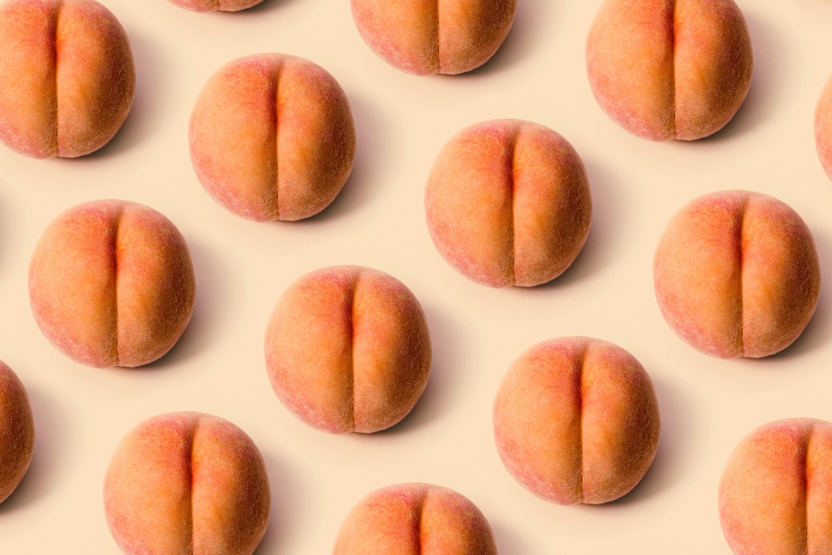 A grid of a freshly picked ripe peaches on a peach background