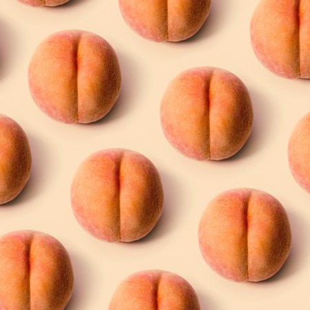 A grid of a freshly picked ripe peaches on a peach background