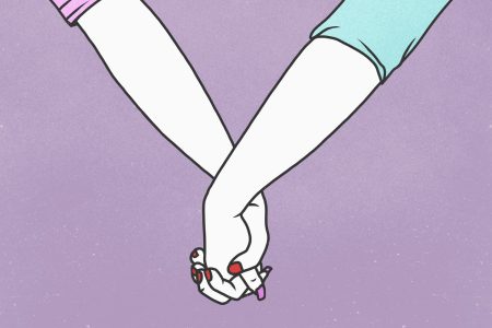 Cropped hands of lesbian couple holding hands against purple background