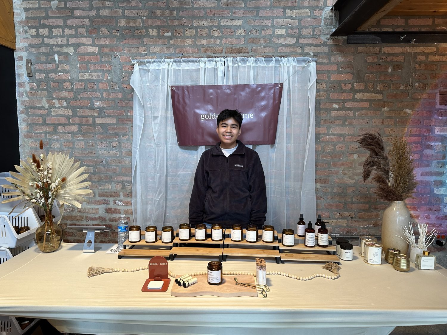 Daniel Pelaez standing behind his displayed candles and other products for Golden Home