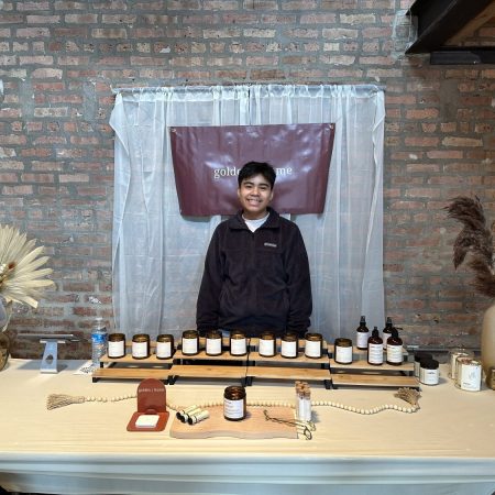 Daniel Pelaez standing behind his displayed candles and other products for Golden Home